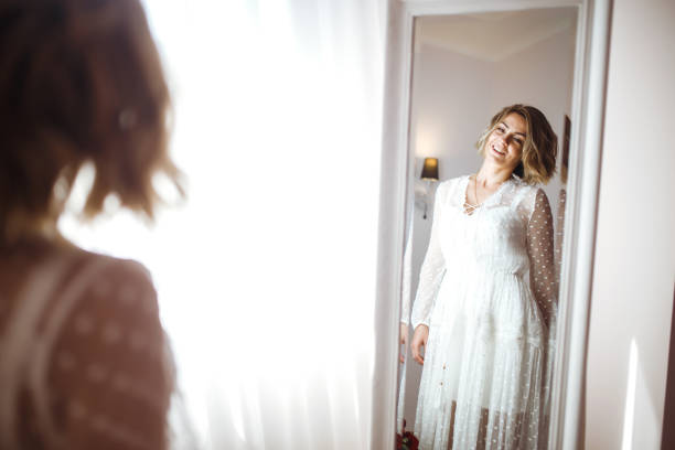 istock The bride smiles and poses in front of the mirror. 1269110657