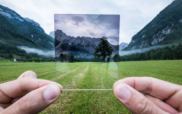 fotografo professionista che tiene in mano il vetro nd gradient filter apprezzando un effetto. valle di logar, slovenia. - polarization foto e immagini stock