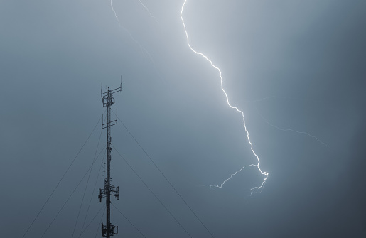 Intense lightning strike near a cellular transmission tower.