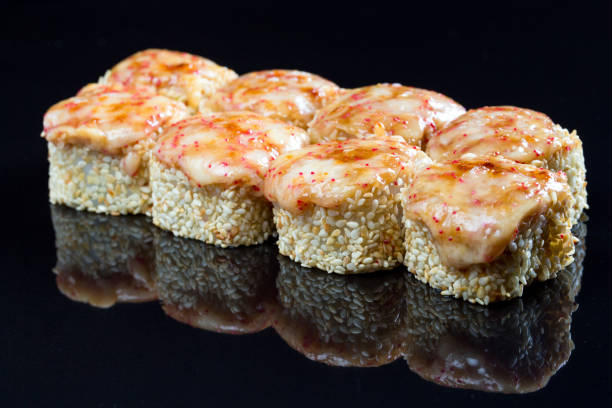 istock Sushi rolls with squid, mussel and cheese on a black background. 1269120616