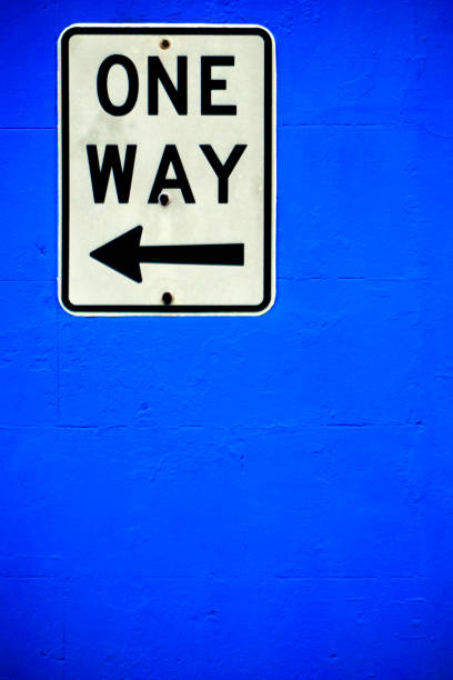 istock One Way traffic sign on a bright blue painted wall 1269122615