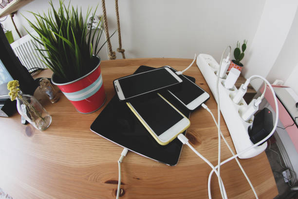 Charged mobile phones and tablets chargers and mobile phones on the table, technoliji charging system. wooden flash drive stock pictures, royalty-free photos & images