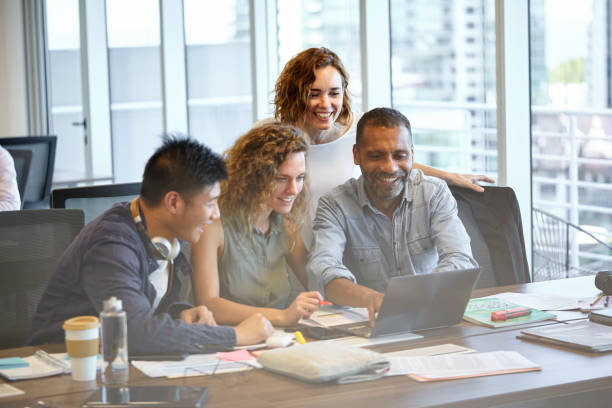 istock Smiling business people using laptop 1269127360