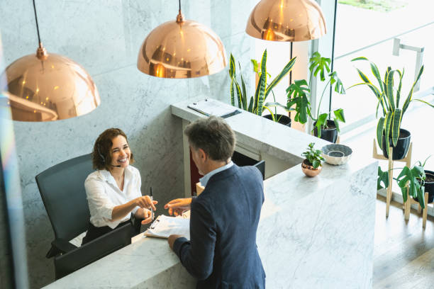 istock Receptionist giving pen to businessman 1269127487