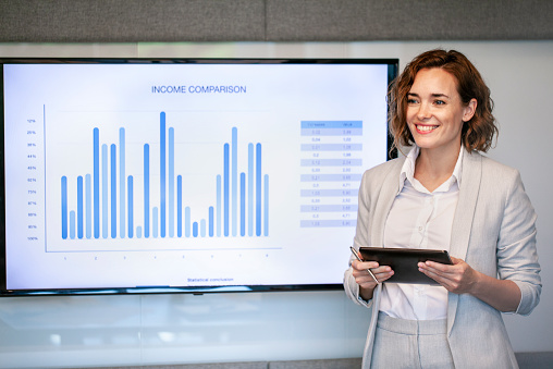 Smiling mature businesswoman giving presentation in conference room