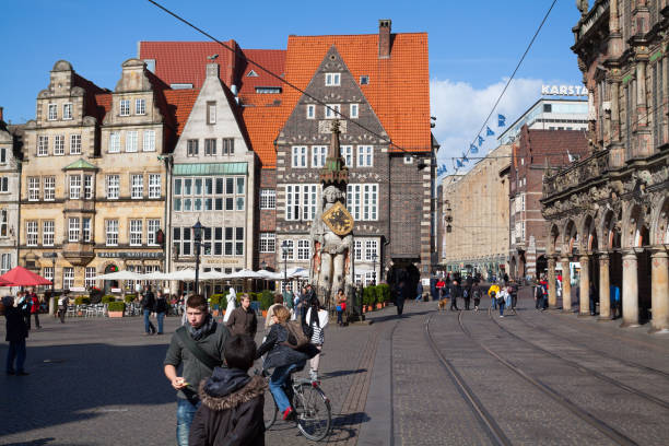 Unesco heritage old square Markt of Bremen with old town hall, Roland statue on square and old row houses. Many people and tourists are in street and on square