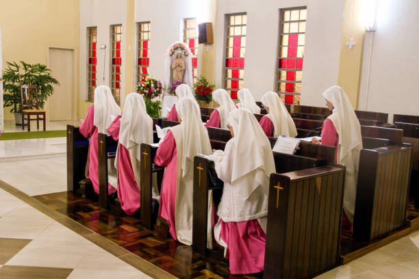 monjas cantando y rezando la oficina de alabanza al santísimo sacramento - nun praying clergy women fotografías e imágenes de stock