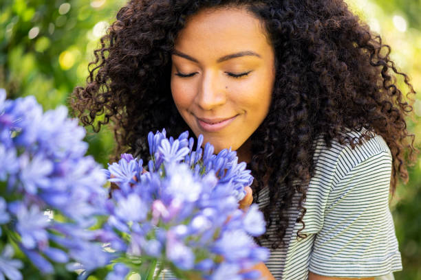 istock Young woman smelling flowers 1269131165