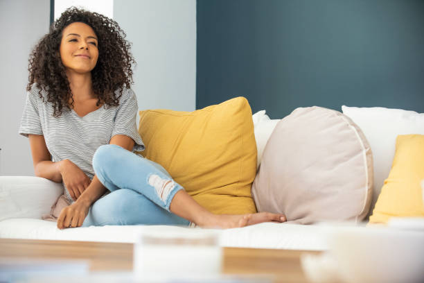 istock Young woman sitting on sofa 1269131213
