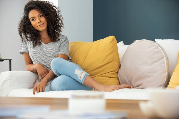istock Young woman sitting on sofa 1269131234