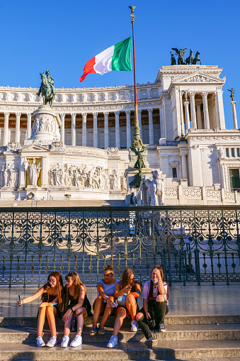 Rome, Italy, August 04 -- Some tourists rest on front the Altare della Patria or Vittoriano, the Italian national monument built in the historic center of Rome on the northern slope of the Campidoglio (the Roman Capitol Hill) and Piazza Venezia between 1885 and 1935 in honor of the first King of Italy, Vittorio Emanuele II. Inside there is the Altare della Patria and the Monument to the Unknown Soldier, the National Memorial Monument dedicated to all Italian soldiers who died in wars. The Altare della Patria is the setting for all the official Italian celebrations, in particular the National Day of the Republic of 2 June and the Liberation Day on April 25th. Image in High Definition format.