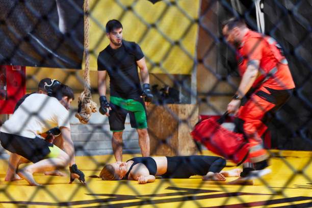 istock Accident during martial arts training. Helping unconcious female fighter 1269134059