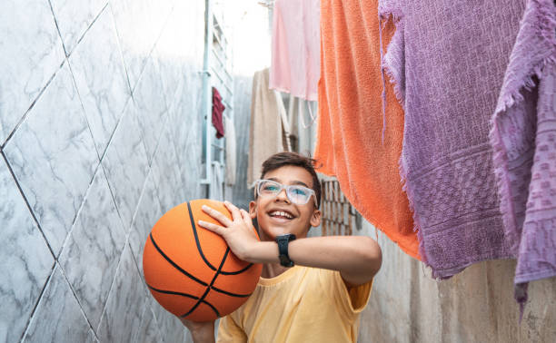 niño jugando baloncesto en el patio de casa - envión fotografías e imágenes de stock