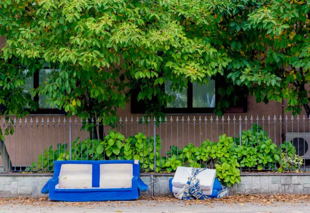 Old thrown out into the street blue sofa