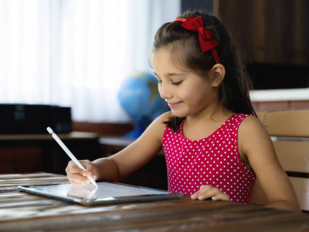 istock Child Girl Is Drawing Picture On Digital Tablet Using Stylus Pen 1269141929