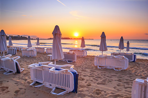Coastal landscape - Beach umbrellas and loungers on the sandy seashore near town of Nesebar, on the Black Sea coast of Bulgaria