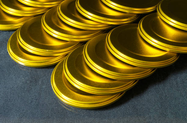 Lid of jar rests upon table close-up gilded colour.metal cover for closing of glass jars.