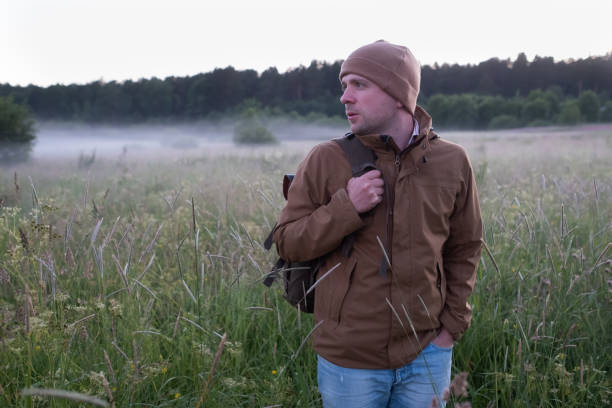 istock Man walking in a misty meadow hiking in the evening. 1269148194