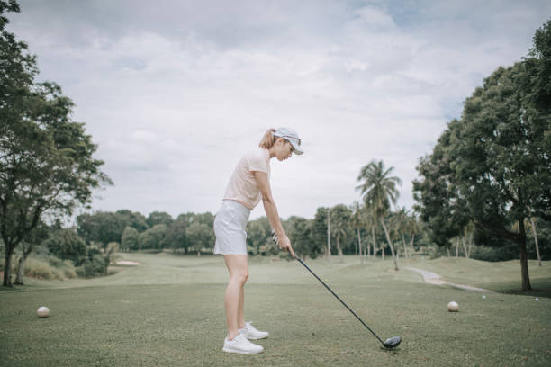 istock asian chinese female golfer teeing off at golf course rear view 1269152534