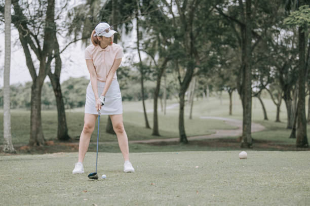 golfista asiática chinesa jogando golfe teeing off - golf women female concentration - fotografias e filmes do acervo