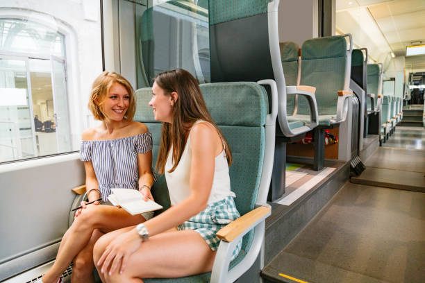 istock Two young girls sitting in modern train and discussing something 1269153500