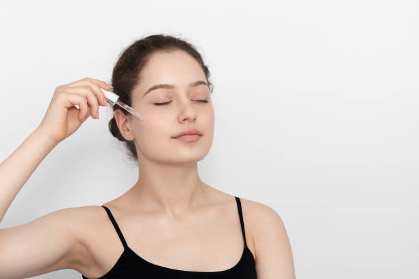 istock Young woman applying serum to her face. 1269153689