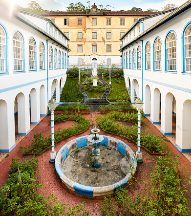 Shot of a landscaped courtyard with fountain in old building with columns and arches