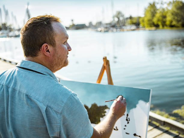 istock Man painting at the Lake shore 1269154624