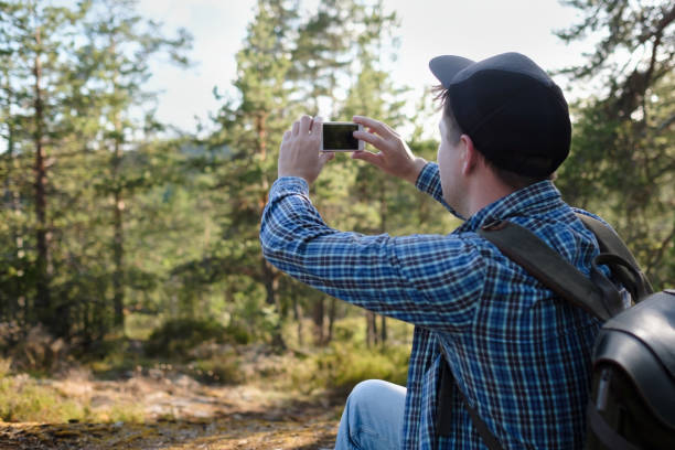 istock Man makes photos on a smartphone in the forest during hiking 1269154888