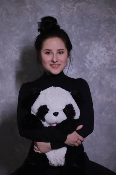 istock brunette in black turtleneck holding big fluffy toy panda 1269156148