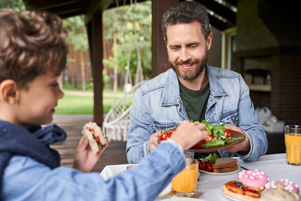istock Happy father having breakfast with son outdoors 1269156822