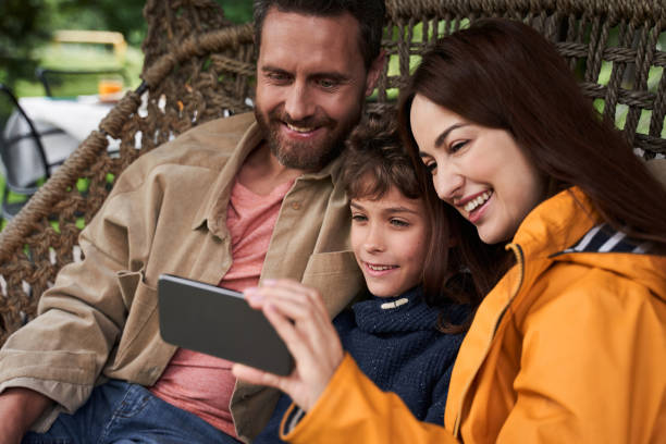 istock Happy parents and their son using cellphone outdoors 1269156867