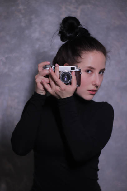 istock brunette in black blouse with old camera 1269159255