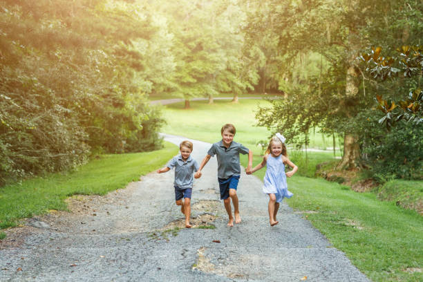 istock Three sibling children running outside 1269159447
