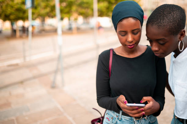 istock Two young women looking at the mobile phone 1269164681