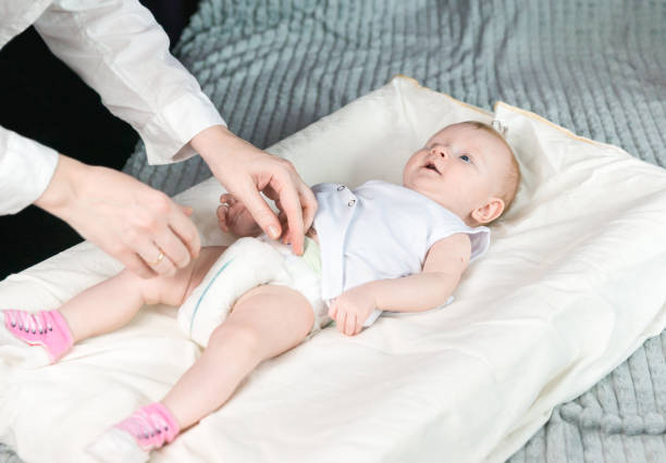 istock Mom changes the babys diaper. The baby is lying on the changing table 1269169668