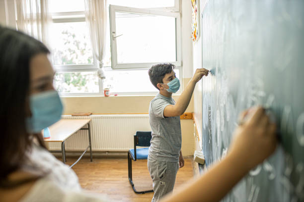 istock Boy and a girl write on the  blackboard 1269170772
