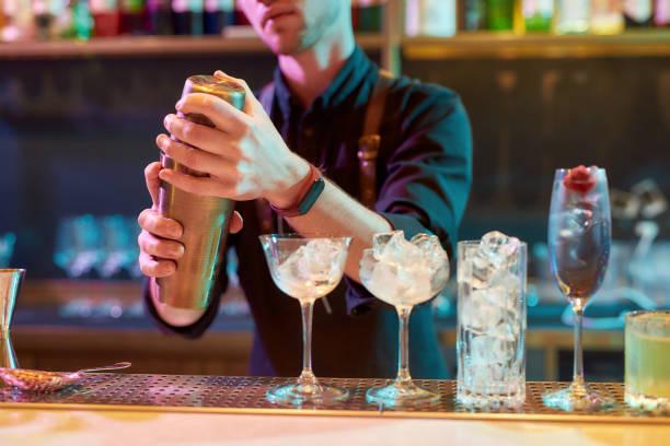 istock Master of Bartending. Cropped shot of male bartender shaking, mixing ingredients while making cocktail alcoholic drink at the bar counter in the night club 1269170913