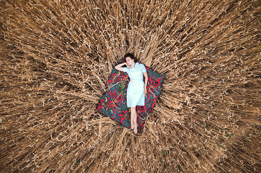 Girl in a white dress lying in wheat field