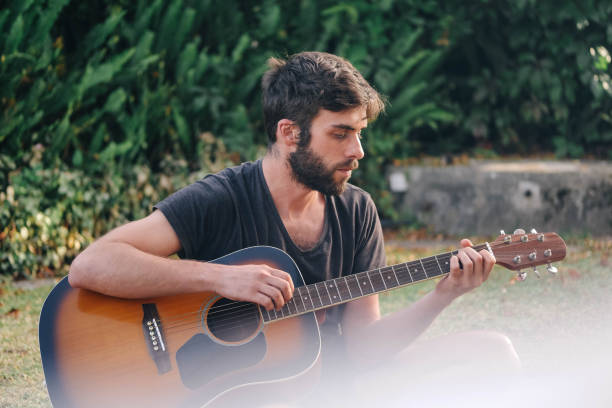 istock A young man is playing guitar in the park 1269173402
