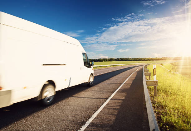 istock Asphalt road on dandelion field with a small truck 1269173585