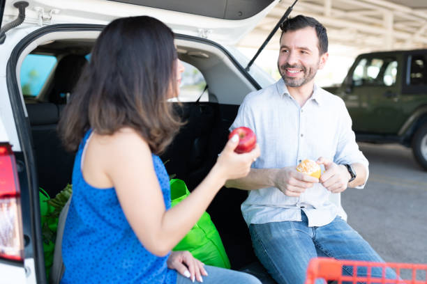 istock Couple Having Fruits While Sitting At Car Trunk 1269173639
