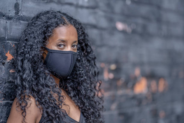 istock African American woman wearing a protective face mask 1269174445