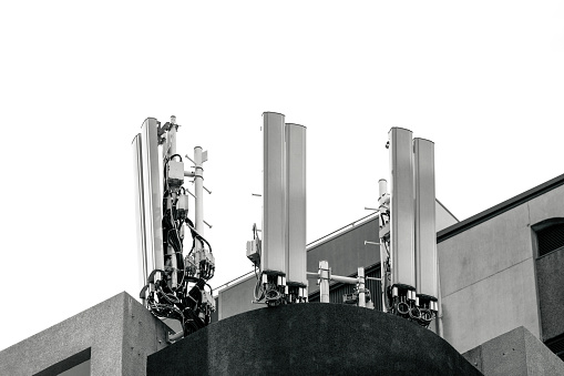 Black and white rooftop cell towers, white background with copy space, full frame horizontal composition