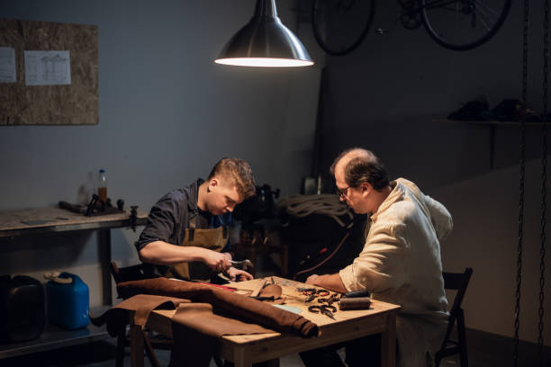 istock an elderly shoemaker and his apprentice create shoes by hand in their workshop with various tools 1269180779