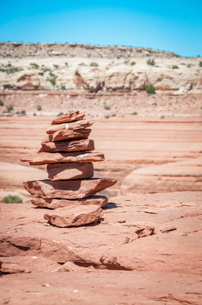 You are not alone A rock cairn in the desert creates a feeling of contentedness with a blue sky in the background slickrock trail stock pictures, royalty-free photos & images