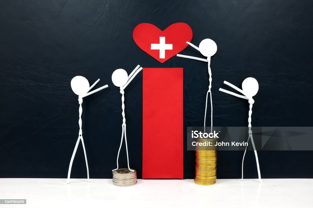 Stick figure reaching for a red heart shape with cross cutout while stepping on stack of coins. Medical care, healthcare and hospital access inequality concept. Healthcare And Medicine Stock Photo