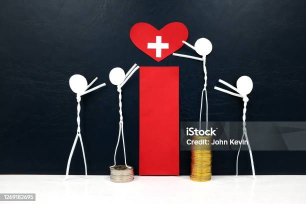 Stick Figure Reaching For A Red Heart Shape With Cross Cutout While Stepping On Stack Of Coins Medical Care Healthcare And Hospital Access Inequality Concept Stock Photo - Download Image Now