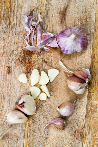 cloves of ripe garlic cloves of ripe garlic on the kitchen table while cooking a dish with garlic, sliced garlic on a cutting Board that is added to the food to give a pleasant taste Relish stock pictures, royalty-free photos & images