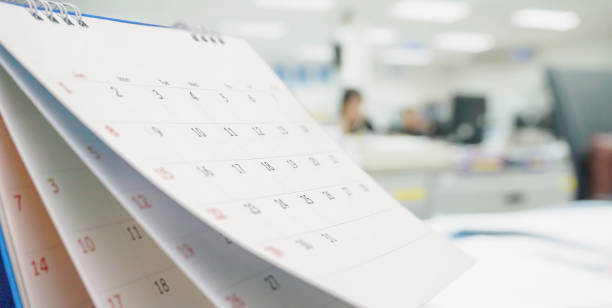 istock Close up white paper desk calendar on table with blurred office interior background 1269201338